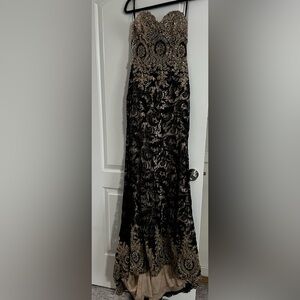 Sleeveless black dress with gems and a long tail